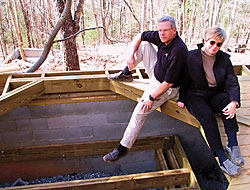 Shoji spa owners Carl Mott and Roberta Jordan sit beside the framed opening for a large tub.