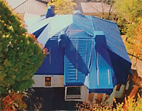 Wolfe House roof with bright blue tarp